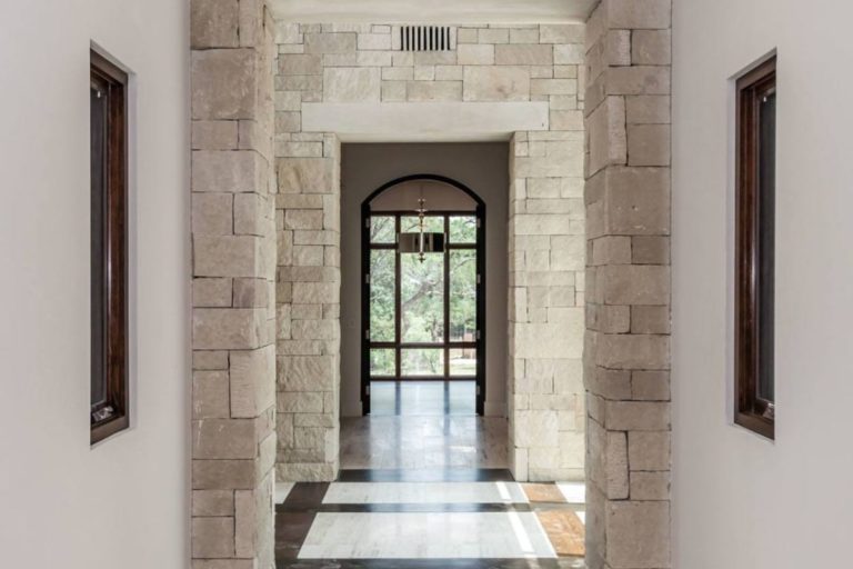 white stone hallway with windows at the end