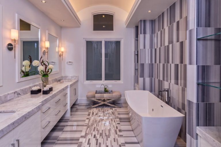 gray and white bathroom with white cabinets