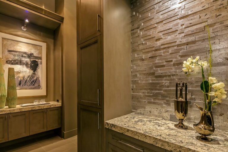 hallway with brown cabinets and granite counter